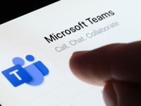 Microsoft Teams app seen in App Store on the screen of ipad and blurred finger pointing at it. Selective focus. Stafford, United Kingdom, May 6, 2023 (Shutterstock) Microsoft Teams app seen in App Store