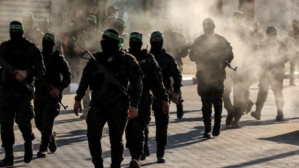 Masked members of the al-Qassam Brigades, the military wing of Hamas, march during a rally in Gaza City on July 20, 2022. (Photo by Mahmud HAMS / AFP) New era for Gaza: Independent technocrats to take the helm after faction deal