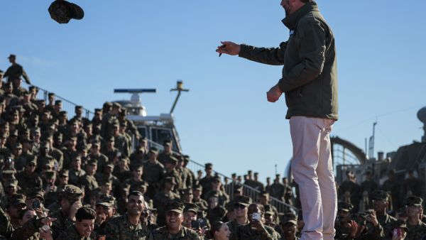 OCEANSIDE, CALIFORNIA - OCTOBER 18: U.S. Marines throw their covers on stage for U.S. Vice President JD Vance to sign as he arrives to speak at the United States Marine Corps 250th birthday celebration at Marine Corps Base Camp Pendleton on October 18, 2025 in Oceanside, California. The U.S. Marines are marking their 250th anniversary with a live amphibious assault demonstration entitled  (Photo by MARIO TAMA / GETTY IMAGES NORTH AMERICA / Getty Images via AFP) Pentagon turns to Trump’s secret benefactor to fund military salaries
