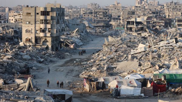 Palestinians walk past the rubble of destroyed buildings in the Sheikh Radwan neighborhood of Gaza City on October 22, 2025. Gaza rubble to be transformed into island